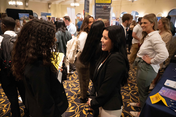 Two women talking at a career fair