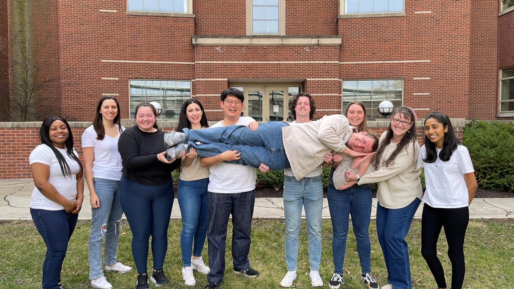 Scott Shaw in the arms of his graduate student group members