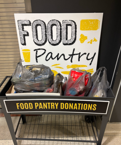Tray labeled food pantry donations filled with plastic grocery bags of food