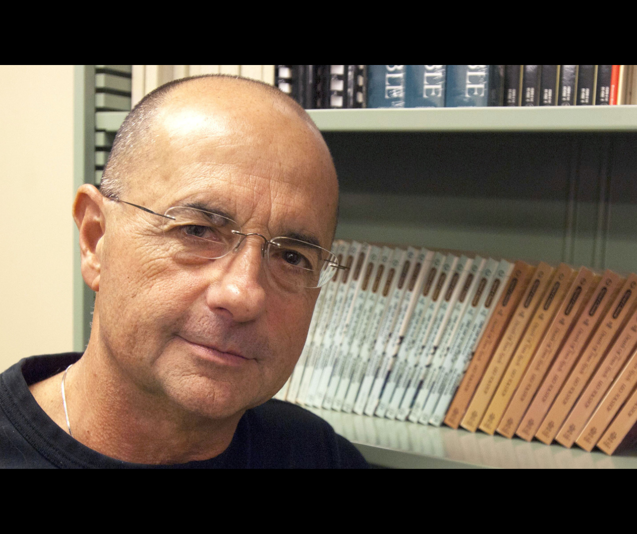 portrait of Jay Holstein in front of a bookshelf