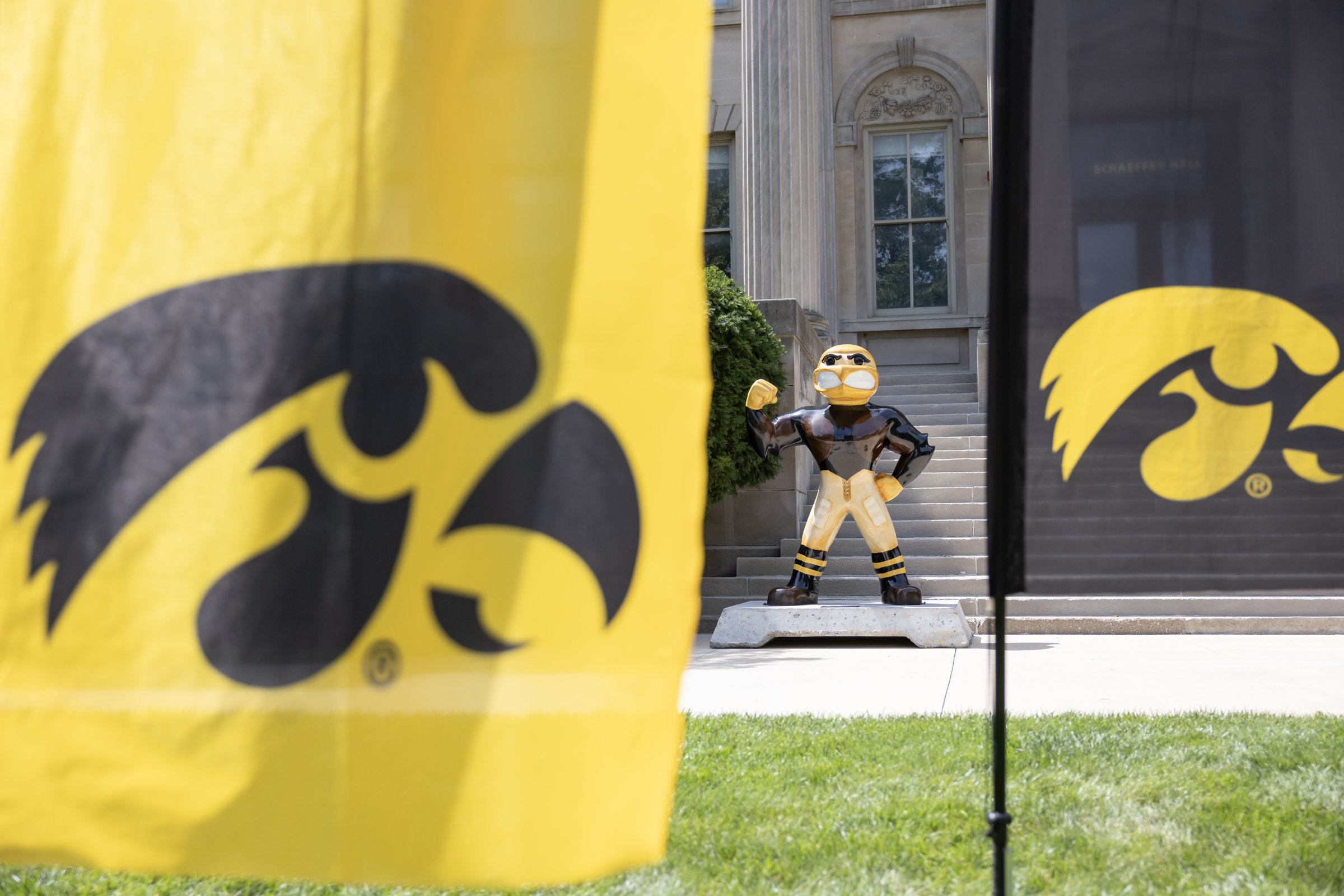 a Hawkeye banner with a statue of Herky in the background