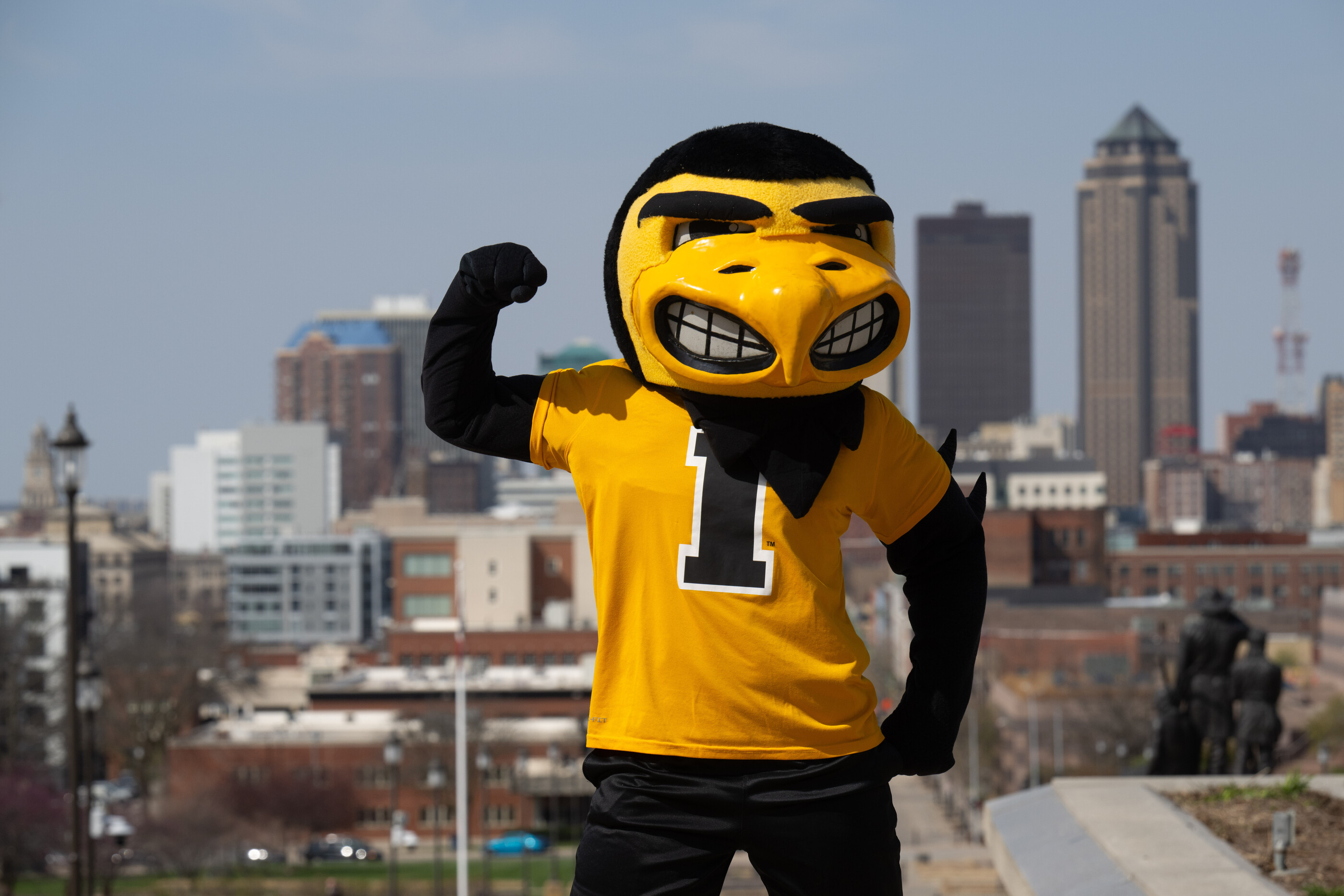 Herky stands victorious with Iowa City landmarks in the background