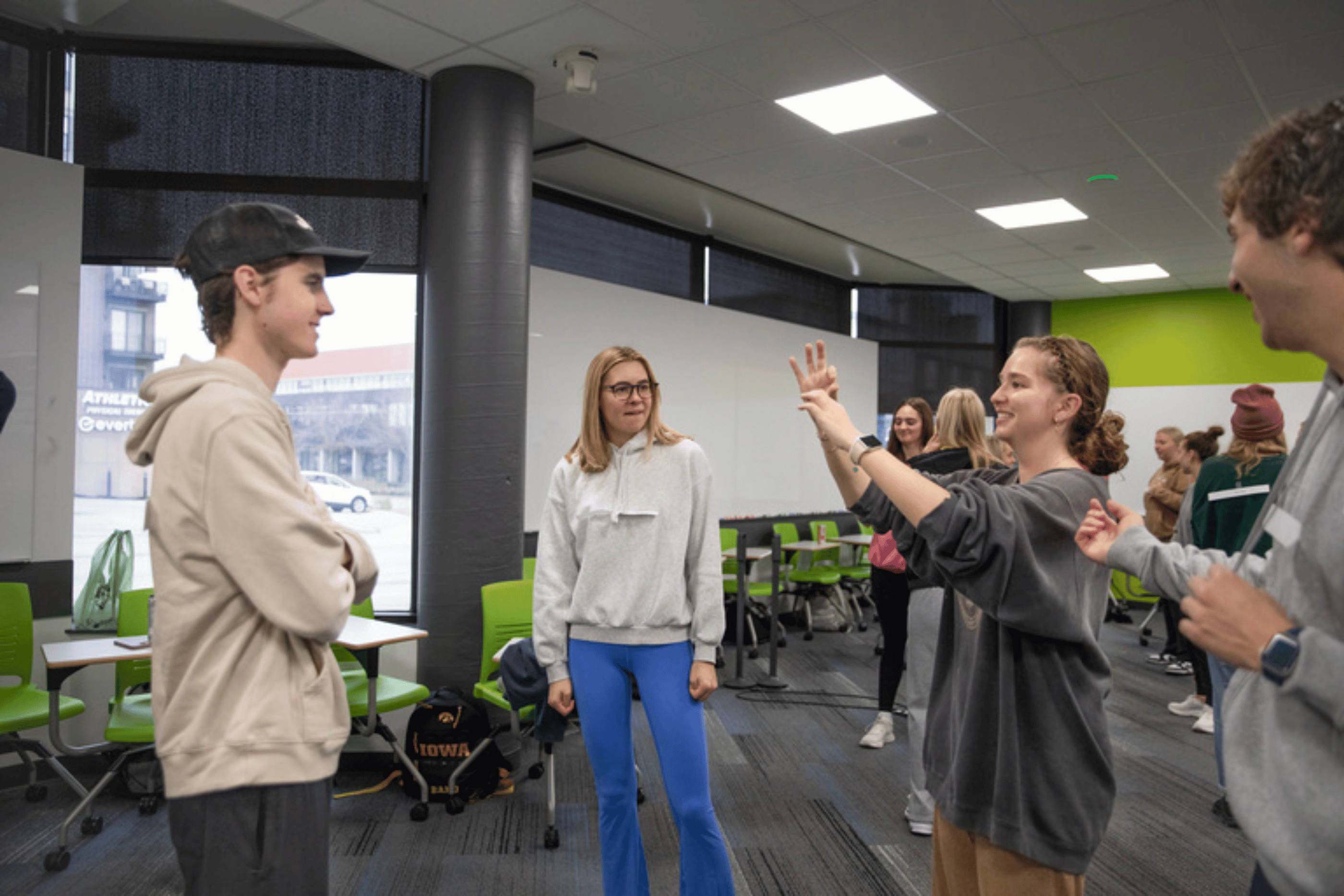 Students stand in a circle signing to one another