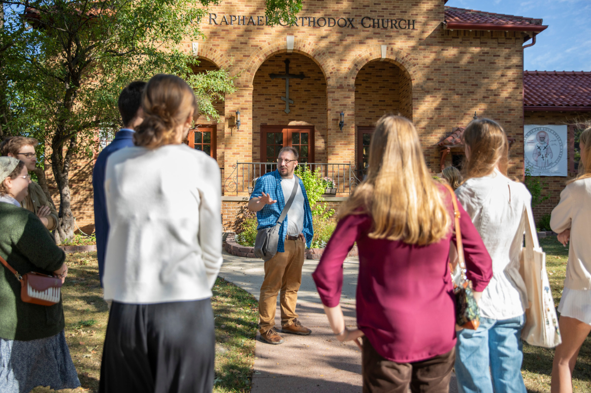 Brandon Dean stands outside an orthodox church talking with his students before going in.