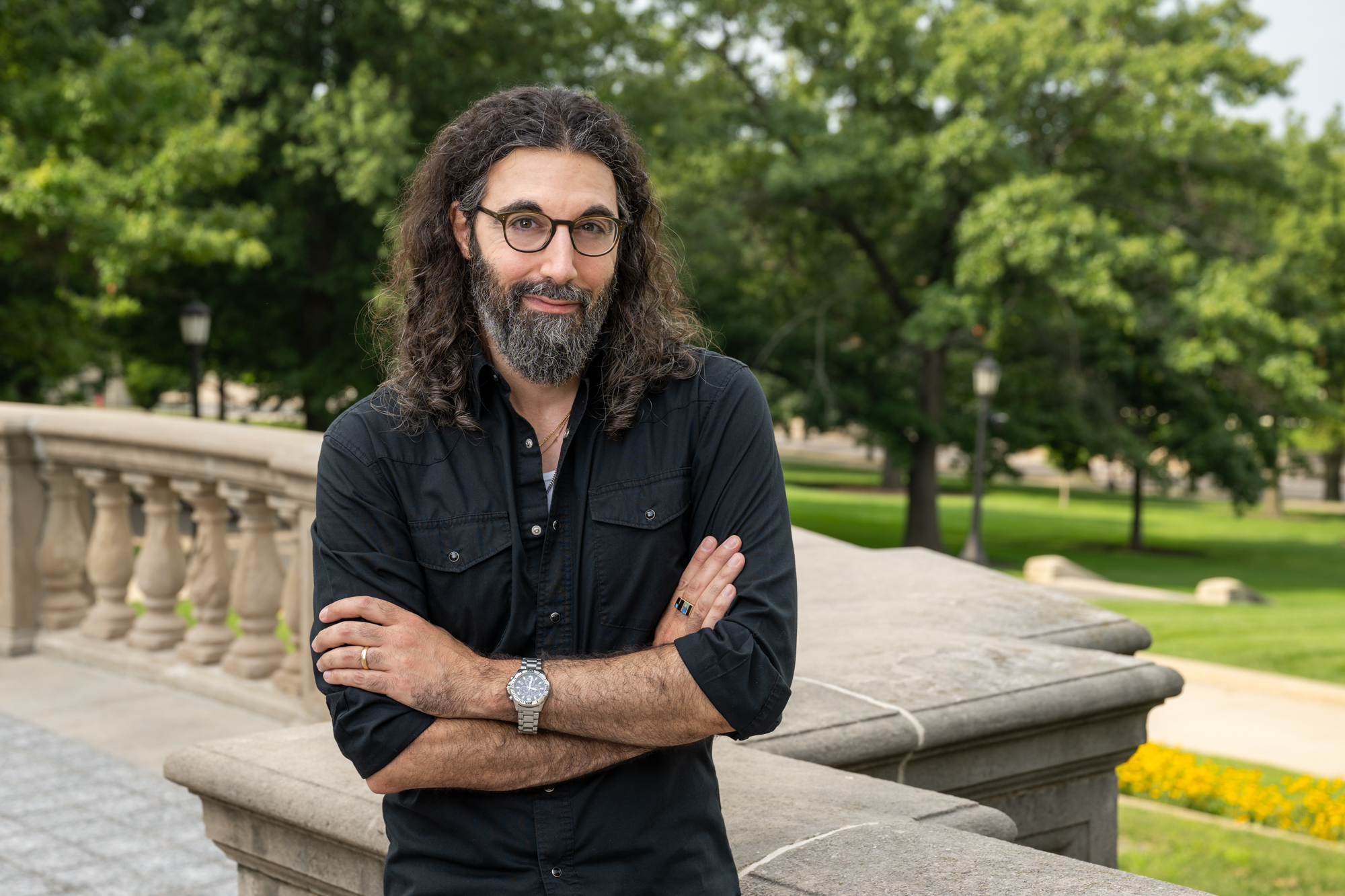 Image: Daniel Khalastchi outdoors, leaning against marble railing of Old Capitol stairs