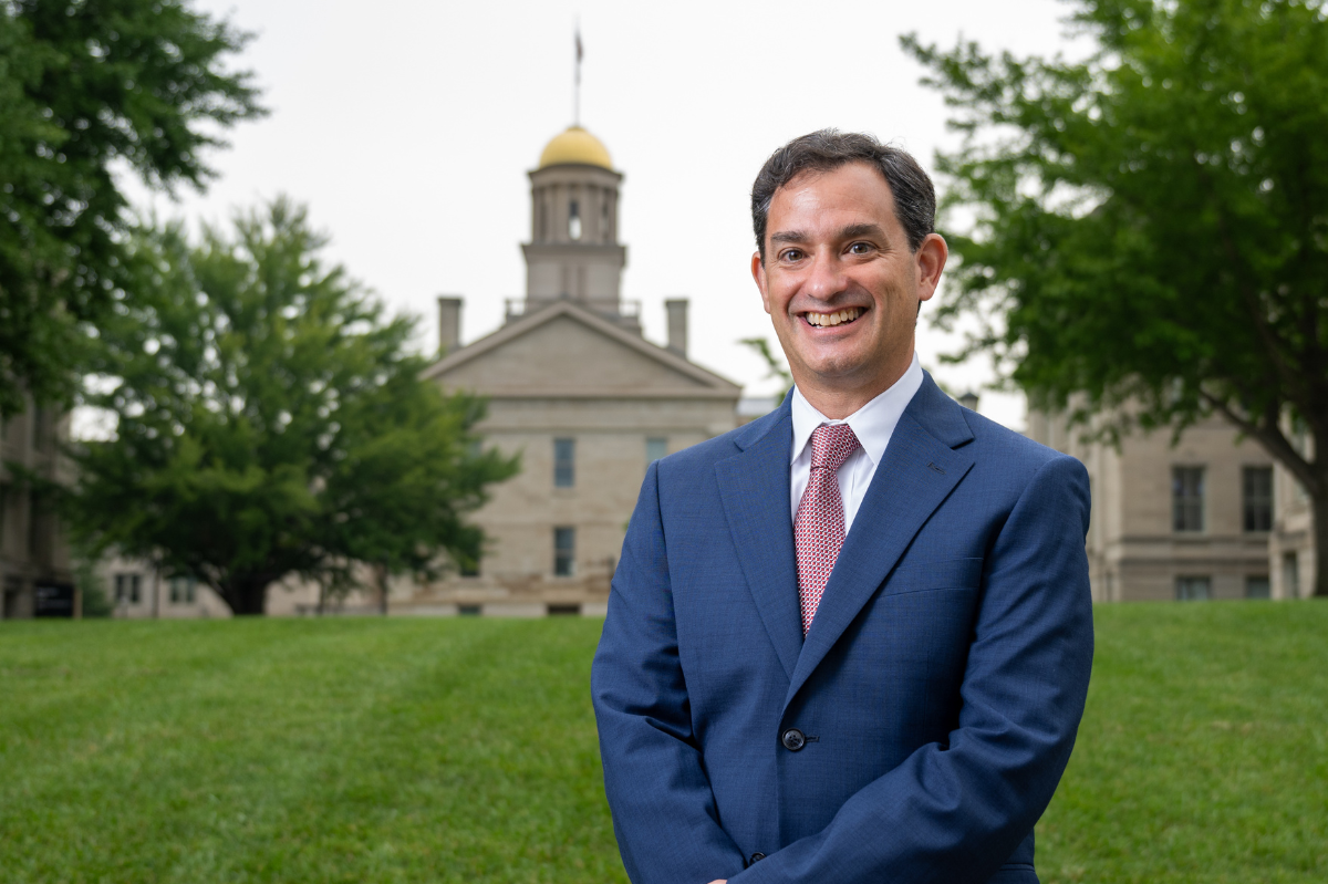 Portrait of David Schwebel standing in front of the lawn to the Old Capitol, with the building visible in the background