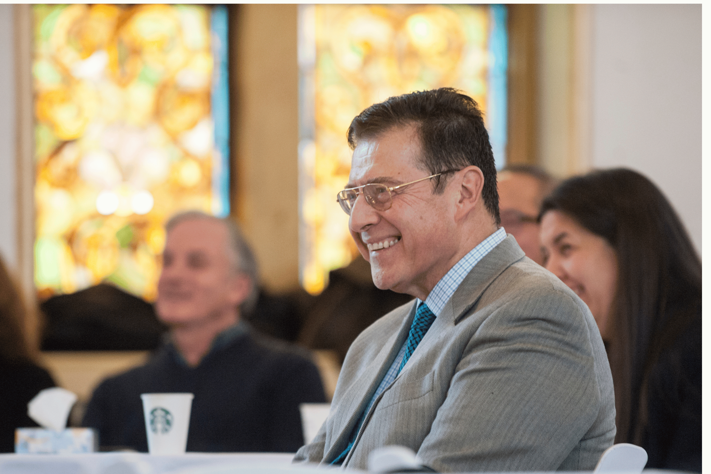Raul Curto sitting at an event and smiling