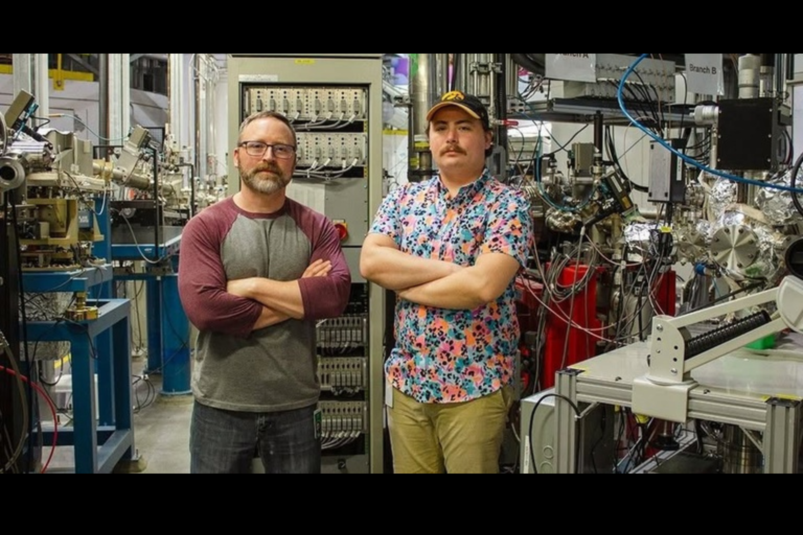 Scott Daly stands, arms cross, next to a student researcher in the lab