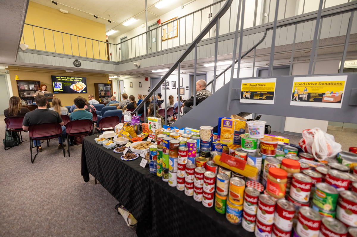 Food donations and a presenter with an audience in the background