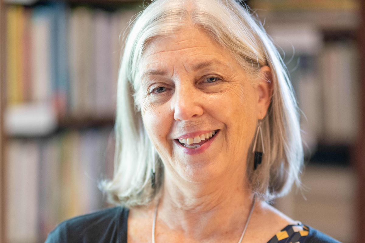 Teresa Mangum smiles in front of full bookshelf