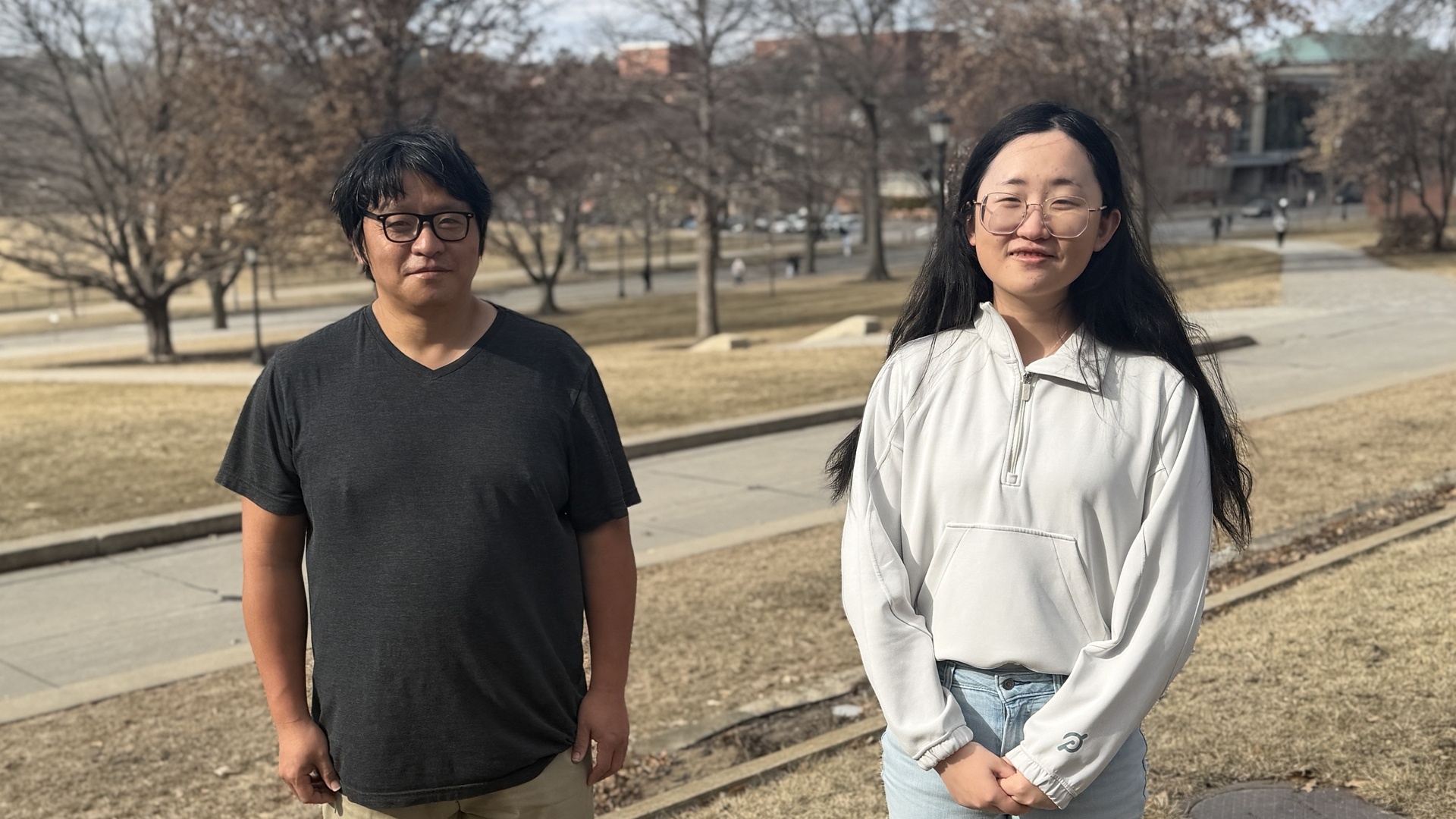 Man (left) and woman (right) pose in an outdoor setting