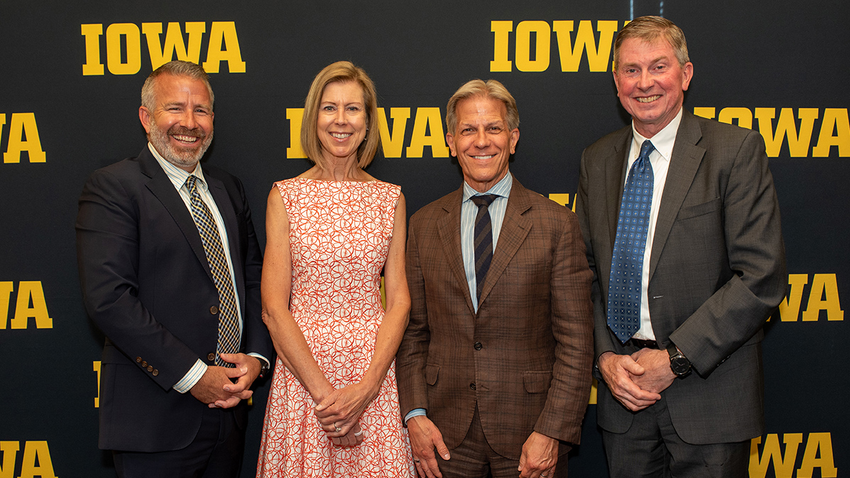 Four people pose in front of a branded Iowa background: David Cwiertny, Sharon Krause, Kyle Krause, and Larry Weber