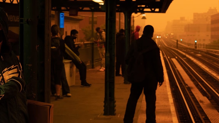 Red tinted sky and smog hover over city train tracks