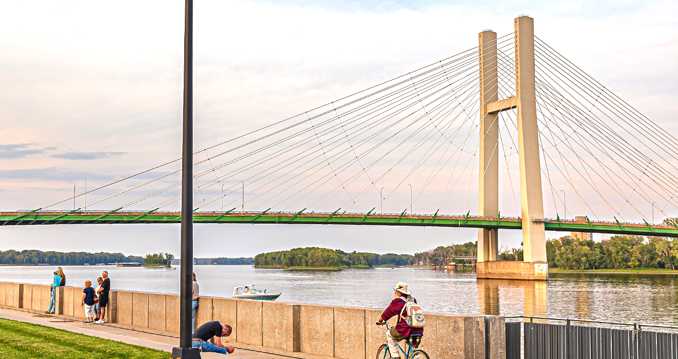 A bridge crosses over the Mississippi River with a park in the foreground