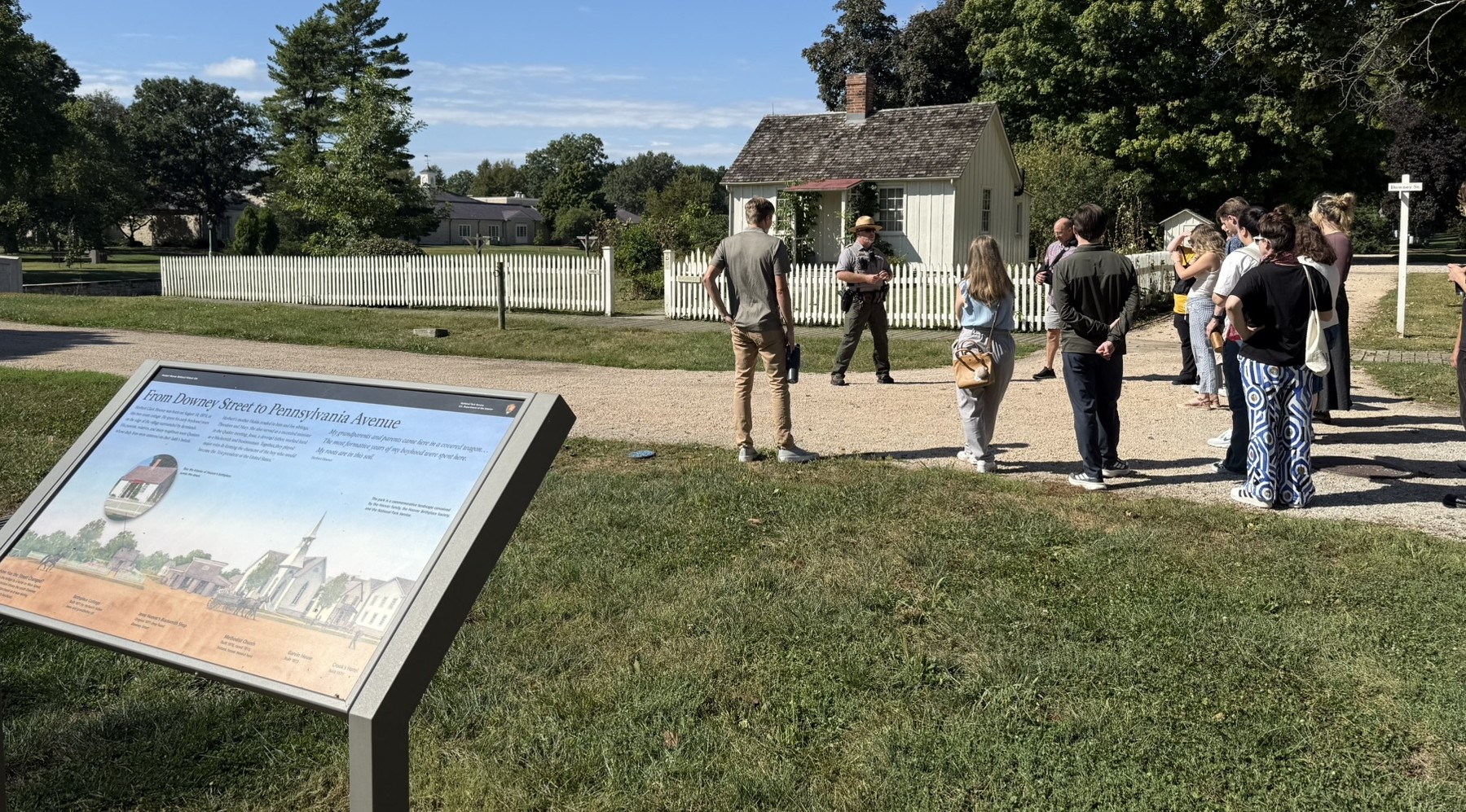 A group of people gather outside Hoover Birthplace Cottage 