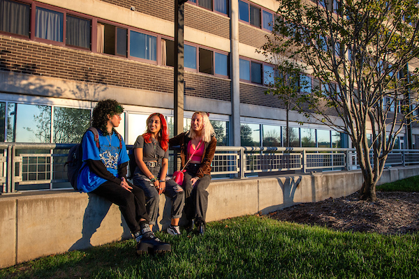 Exterior shot of 3 students by Mayflower Residence Hall