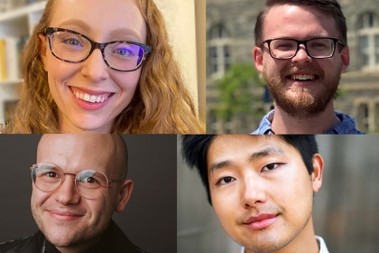 A student holding a phone while sitting in front of a computer