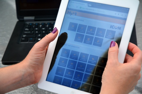 Close up of hands using a tablet to explore the ICON dashboard. 