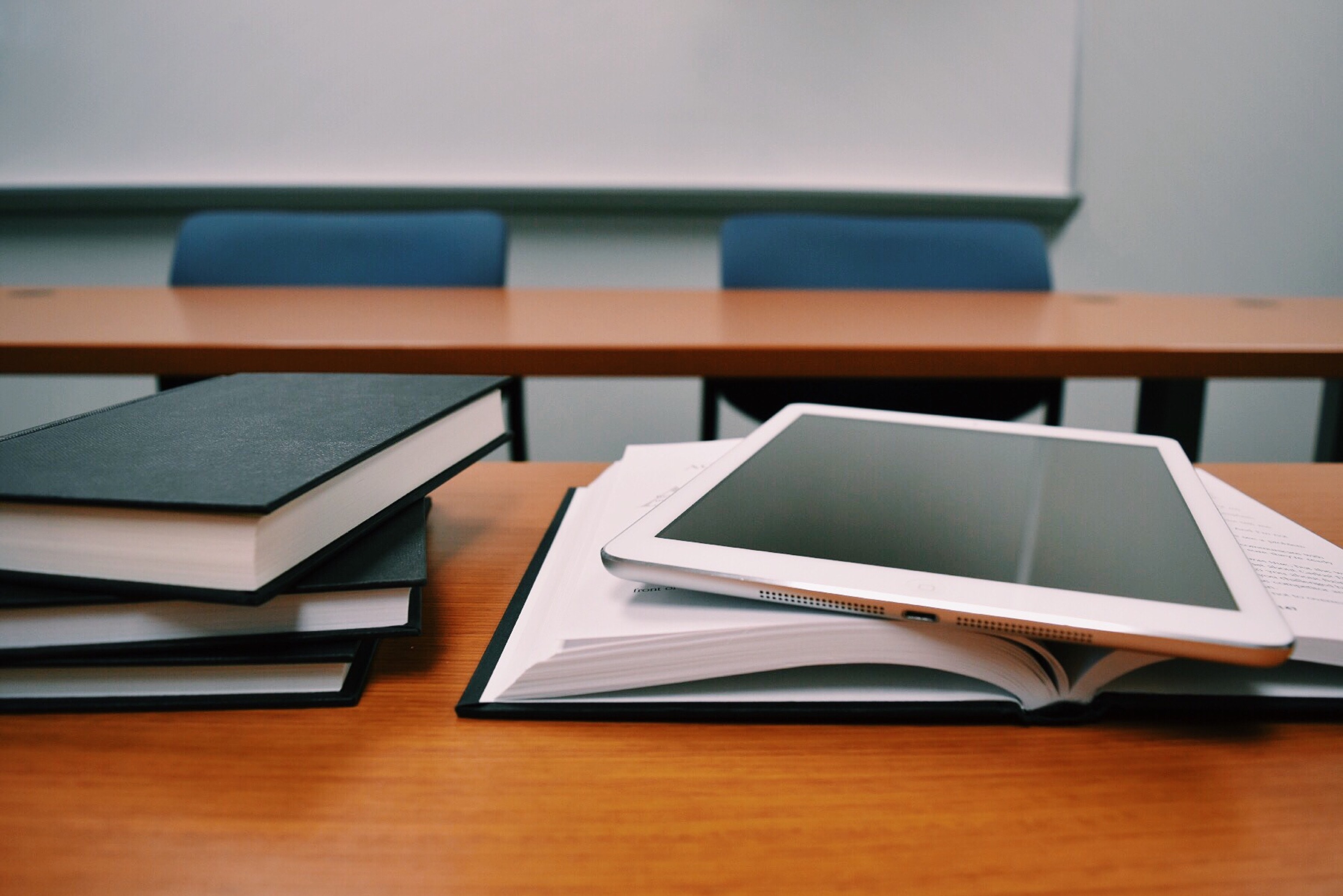 Stack of books with a tablet on top. 