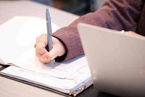 Closeup of a student's hand writing in a notebook. 