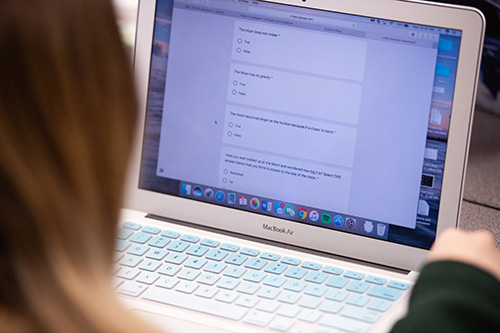 A UI student uses a tablet to access their science book, which is an OER created using Pressbooks.