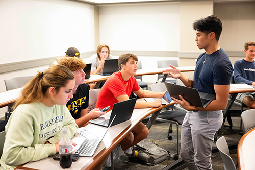 A TA speaks with students in an introduction to accounting class.