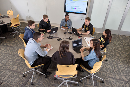 UI students sit around a table in a TILE active learning space.