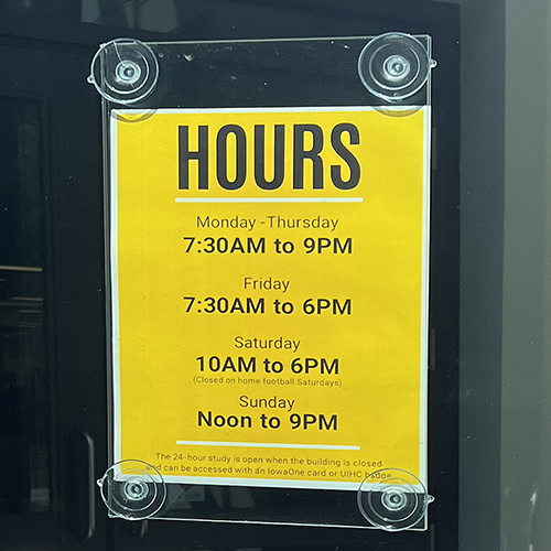 A color photo of the Hardin Library summer hours sign - a yellow background with black writing.