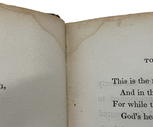 Cropped color photo showing only a little bit of text and water damage to the top of two pages, from Martineau's Life in the sick room, 1844.