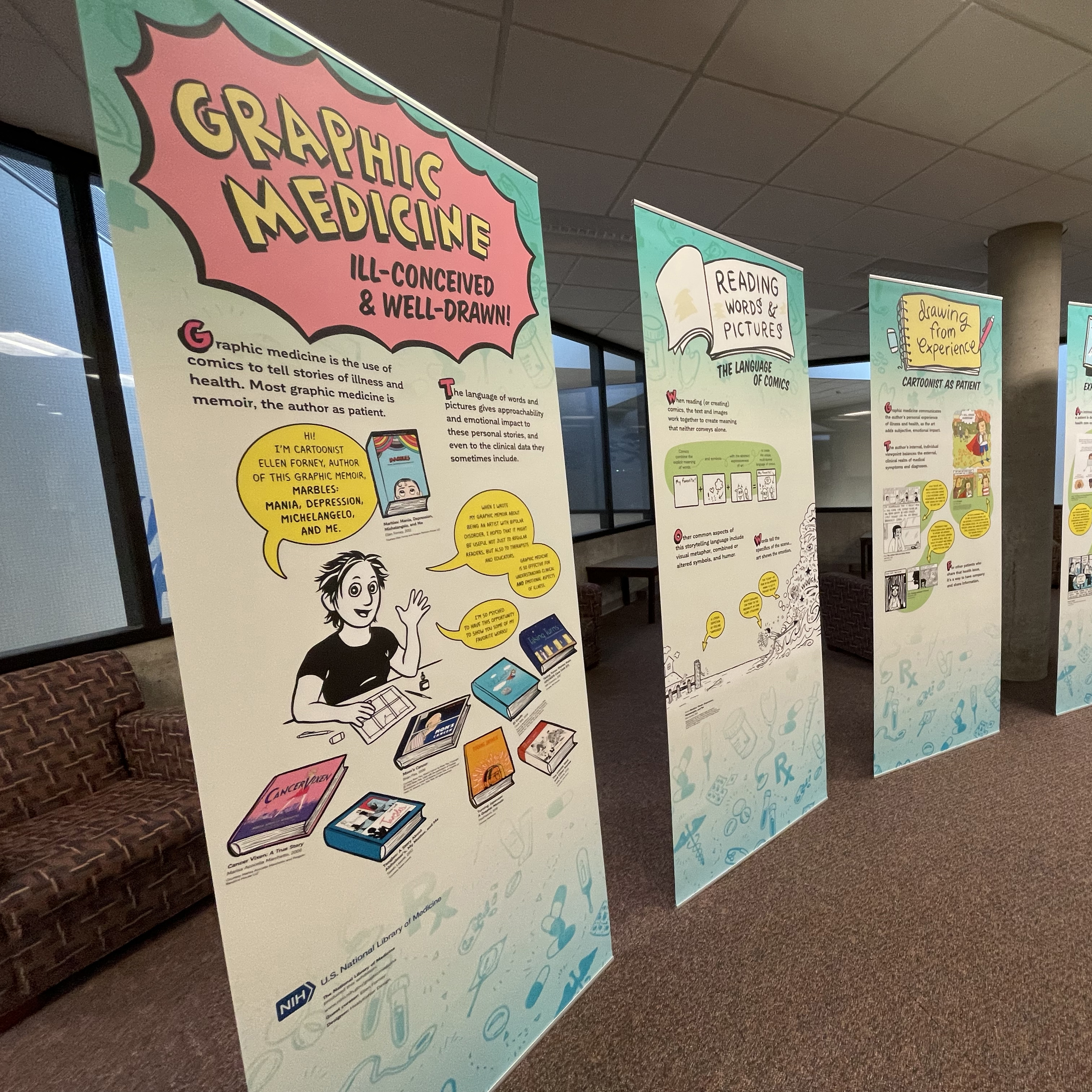 Cropped photograph of the Graphic Medicine exhibit currently on display in the Hardin Library. The Graphic Mdicine logo (pink starburst with yellow block lettering) at the top of the first panel. Four panels are visible, all with a number of drawn images and text.