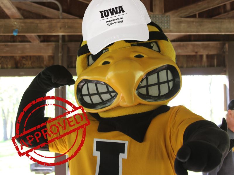 Herky the mascot in a yellow "Iowa" jersey and white cap from the apparel sale labeled "Department of Epidemiology" flexes with a large red "APPROVED" stamp over the image.