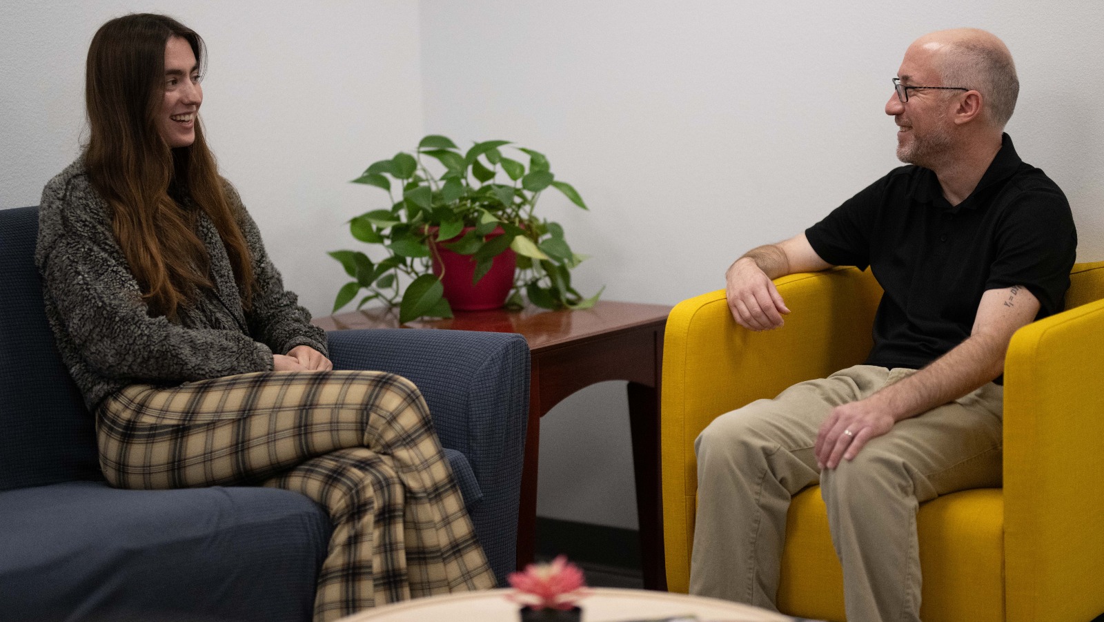 Two people have a conversation on couches in the Center for Social Science Innovation