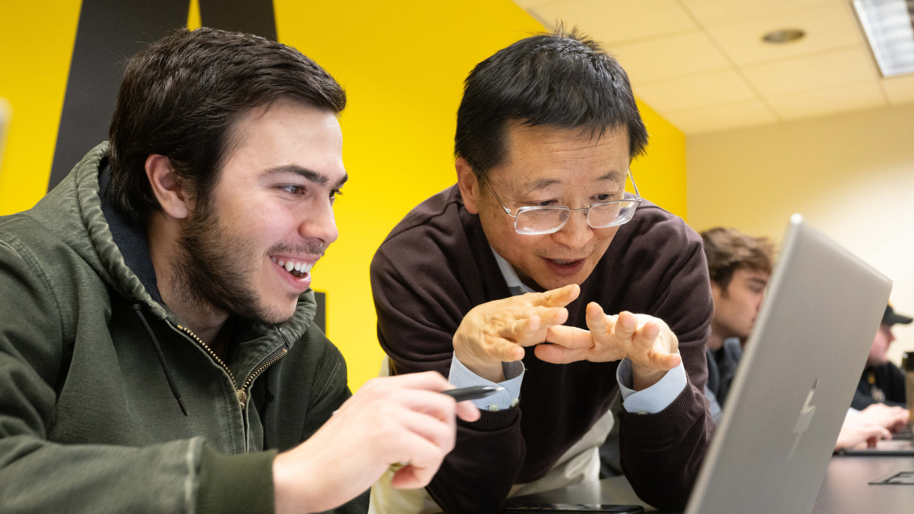 two people looking at a laptop