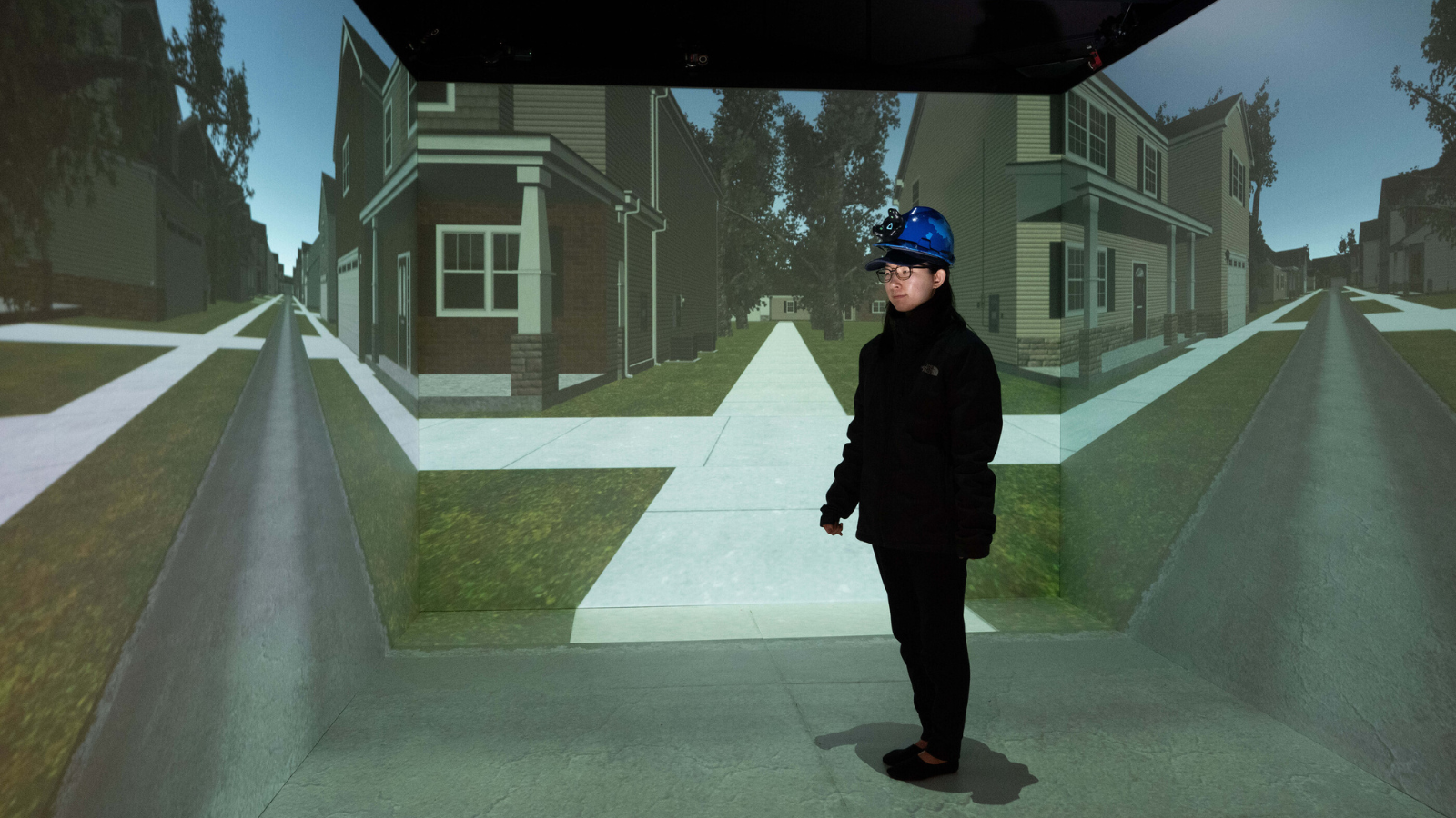A research participant stands in the middle of a street crossing simulator