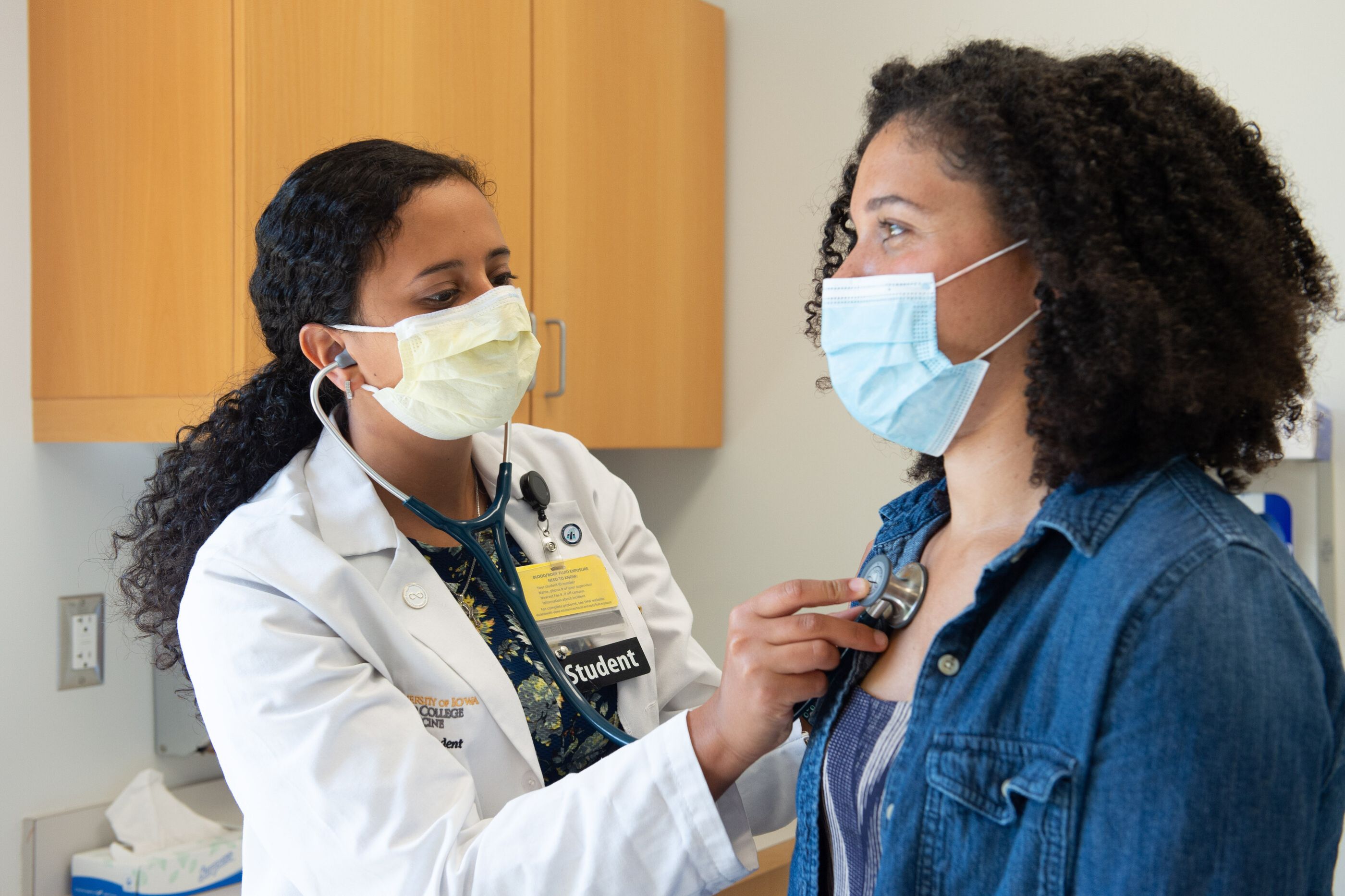 student using stethoscope to listen to patient's heart