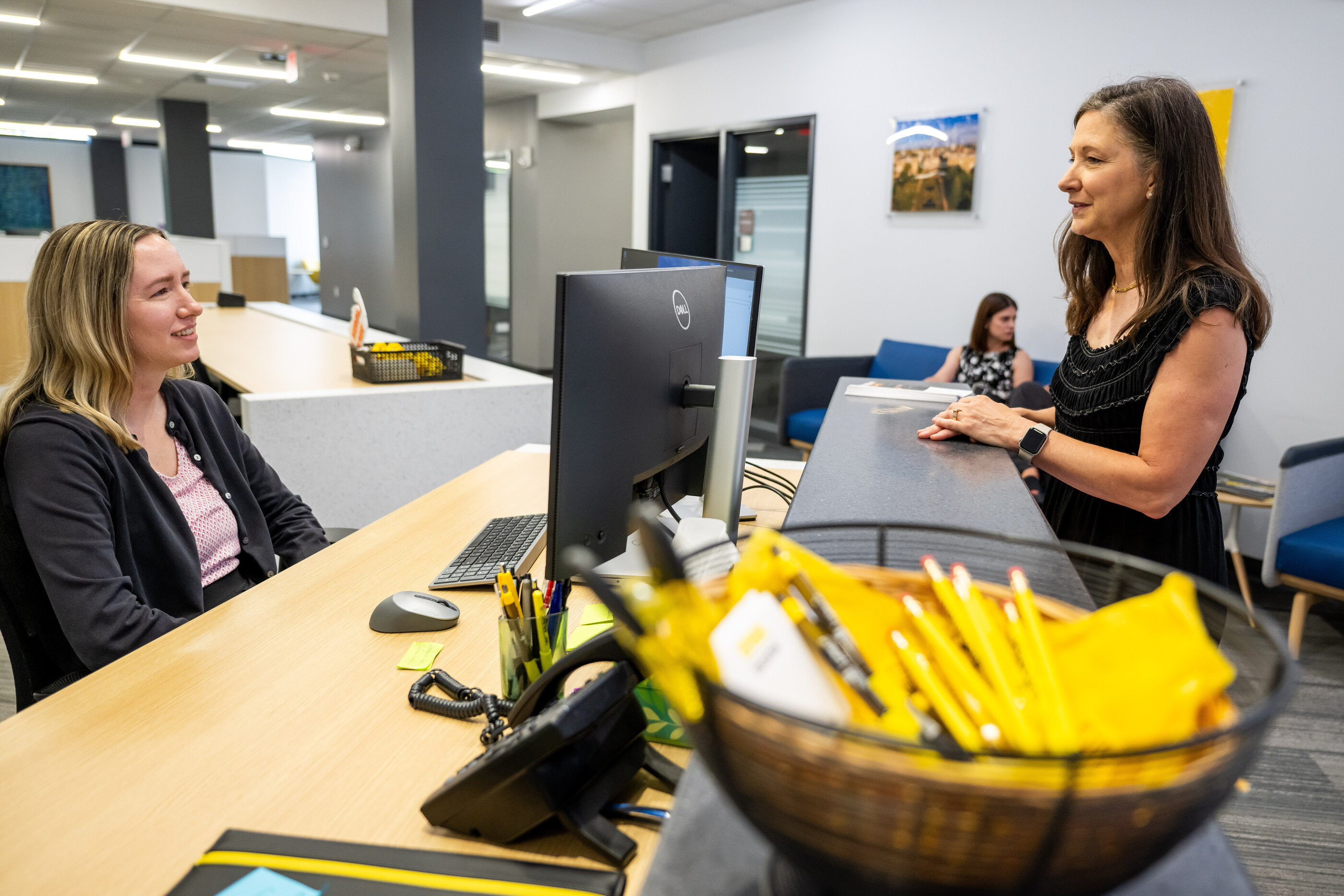 Two UI employees talking over a desk