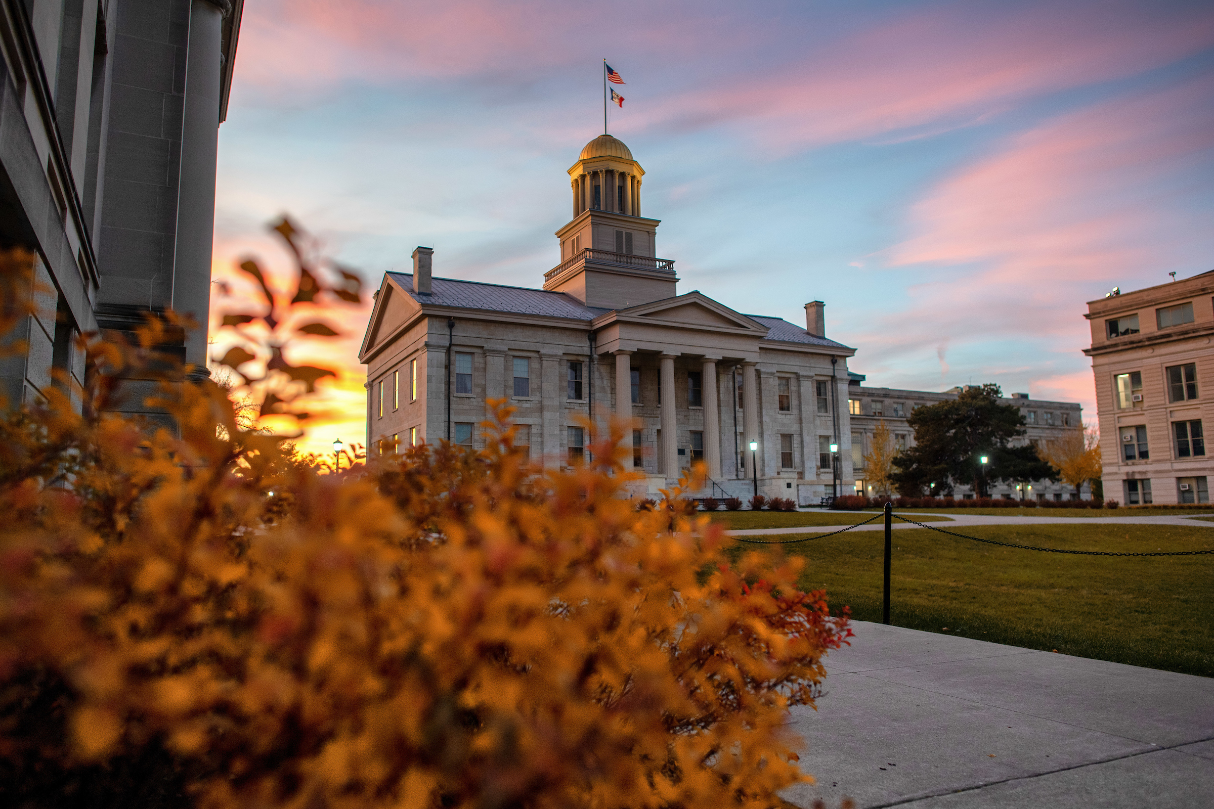 Old Capitol building and a shrub with orange leaves