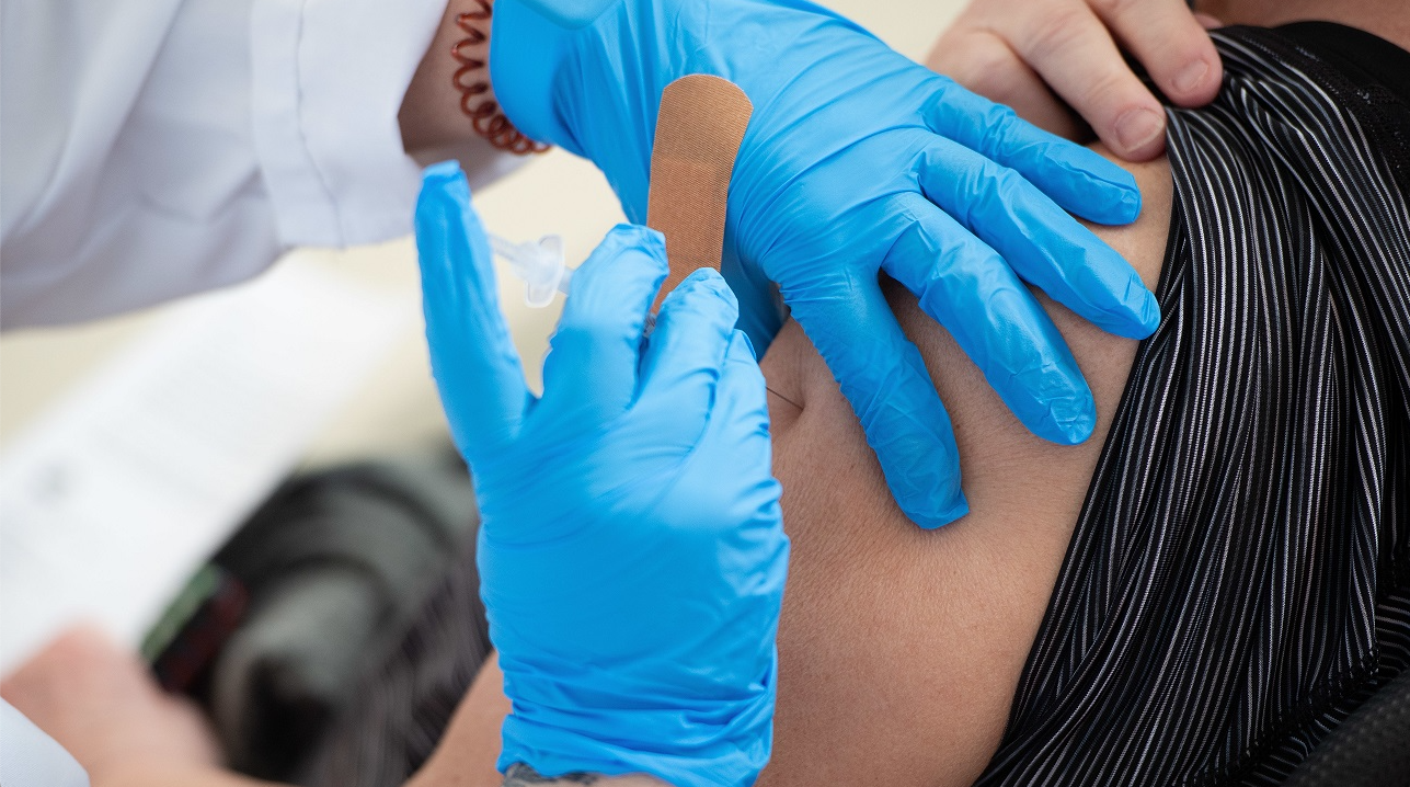 Someone receiving a band-aid after a flu shot