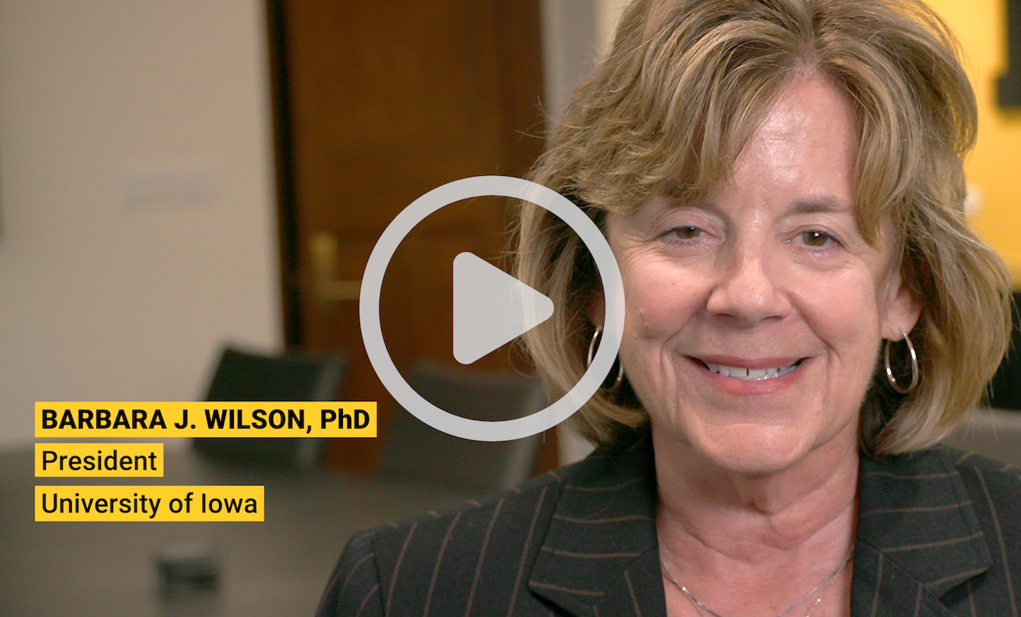 A still of President Wilson from the video with a play button on top
