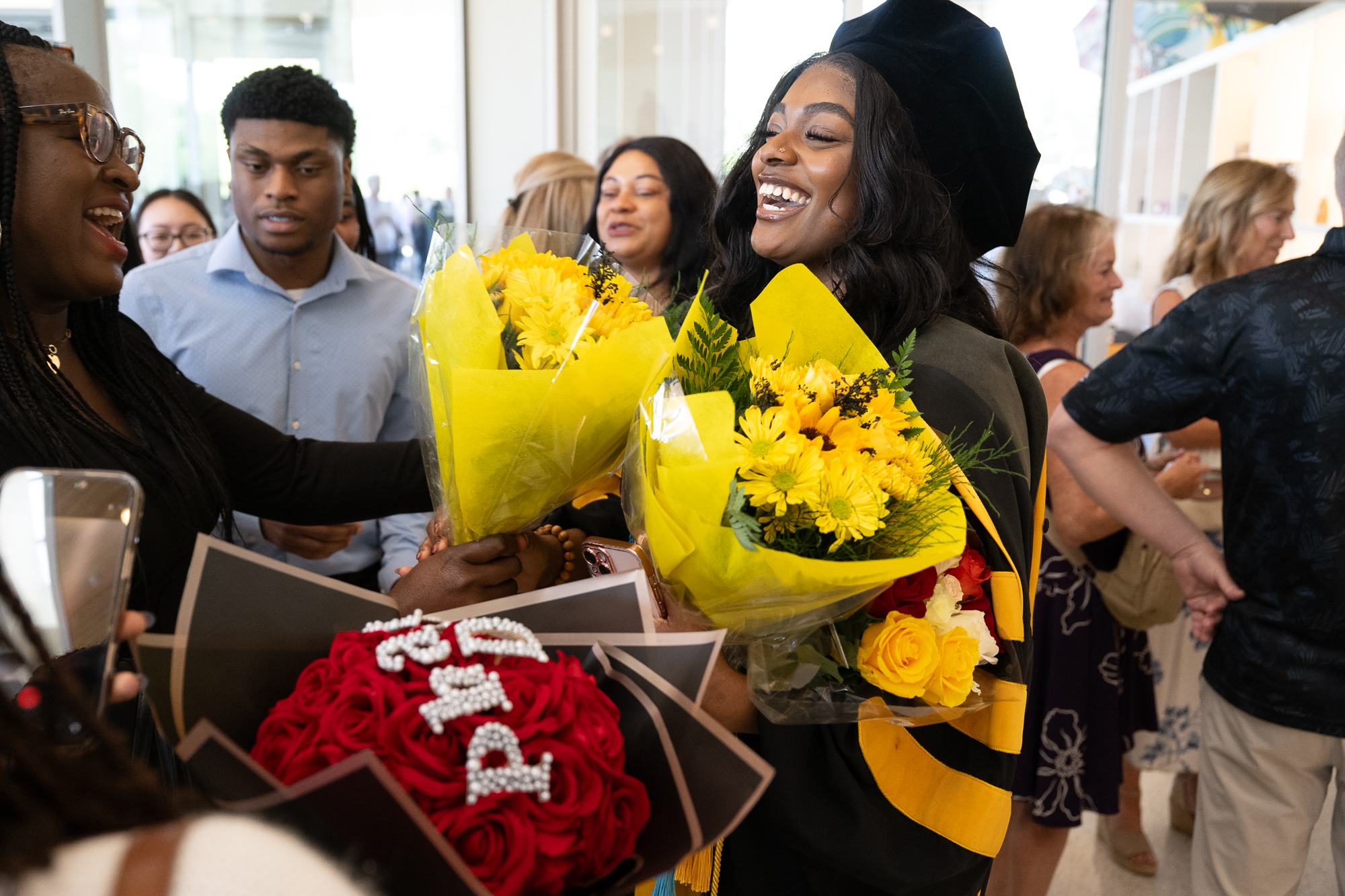 A College of Pharmacy graduate receives bouquets of flowers