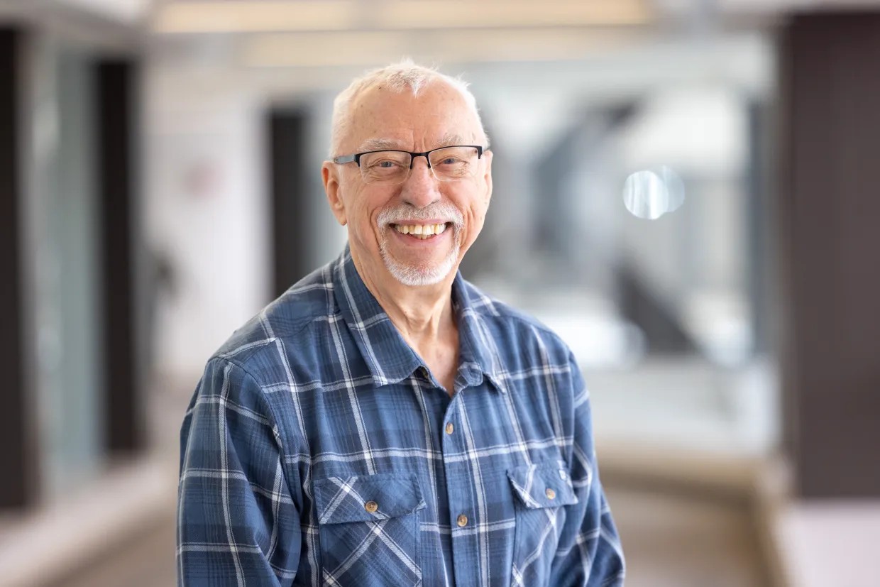 Garry Buettner, a man with white hair and beard, wearing glasses and a blue plaid shirt.