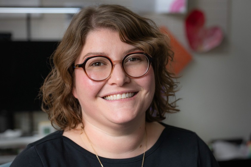 Allison Levine, assistant professor of counselor education in the College of Education. A woman with short, light brown, curly hair, wearing round glasses.