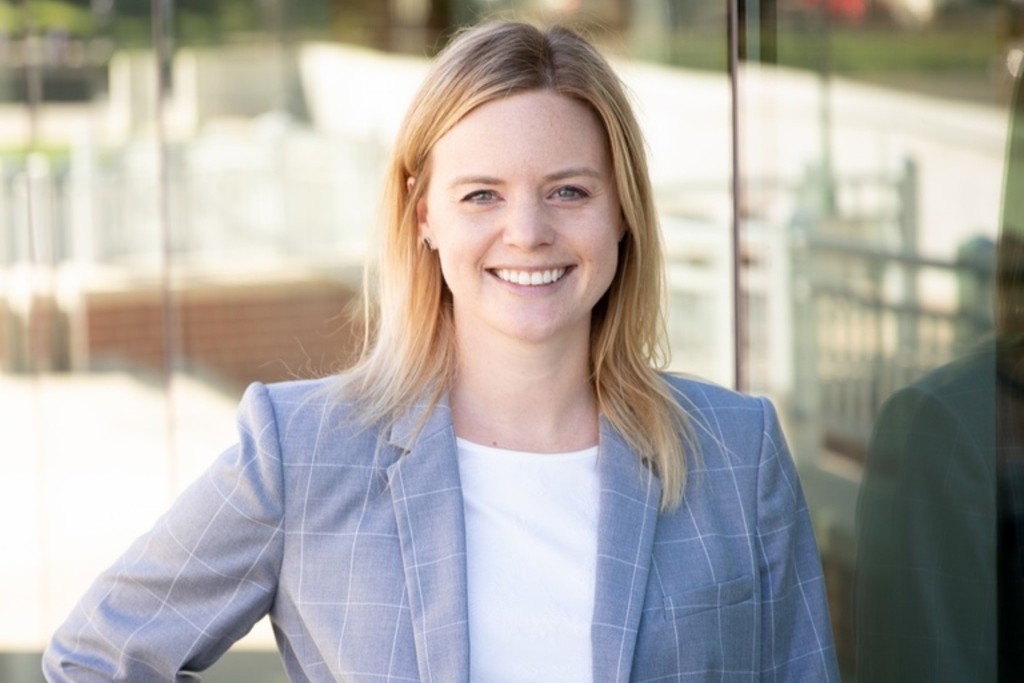 Amanda Elkins, the winner of the 2026 Lola Lopes Award, with medium length blonde hair, parted on the side, wearing a light blue suit jacket and white blouse. 