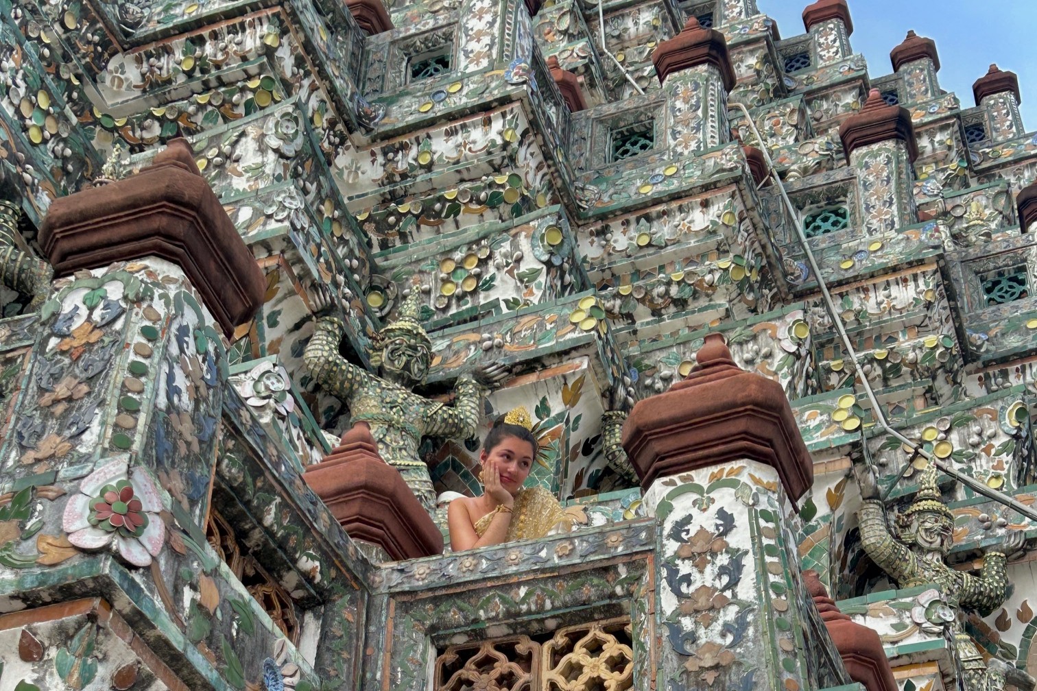 Woman in traditional Thai clothing at Wat Arun temple in Bangkok.
