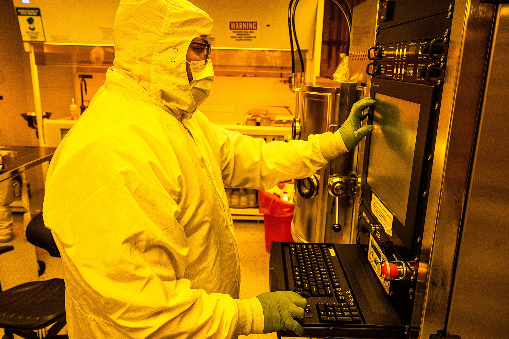 UI researcher in a protective suit and mask running equipment at UI&rsquo;s MATFab.