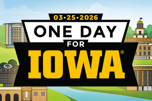 A sign with a river and buildings, that says One Day for Iowa. 