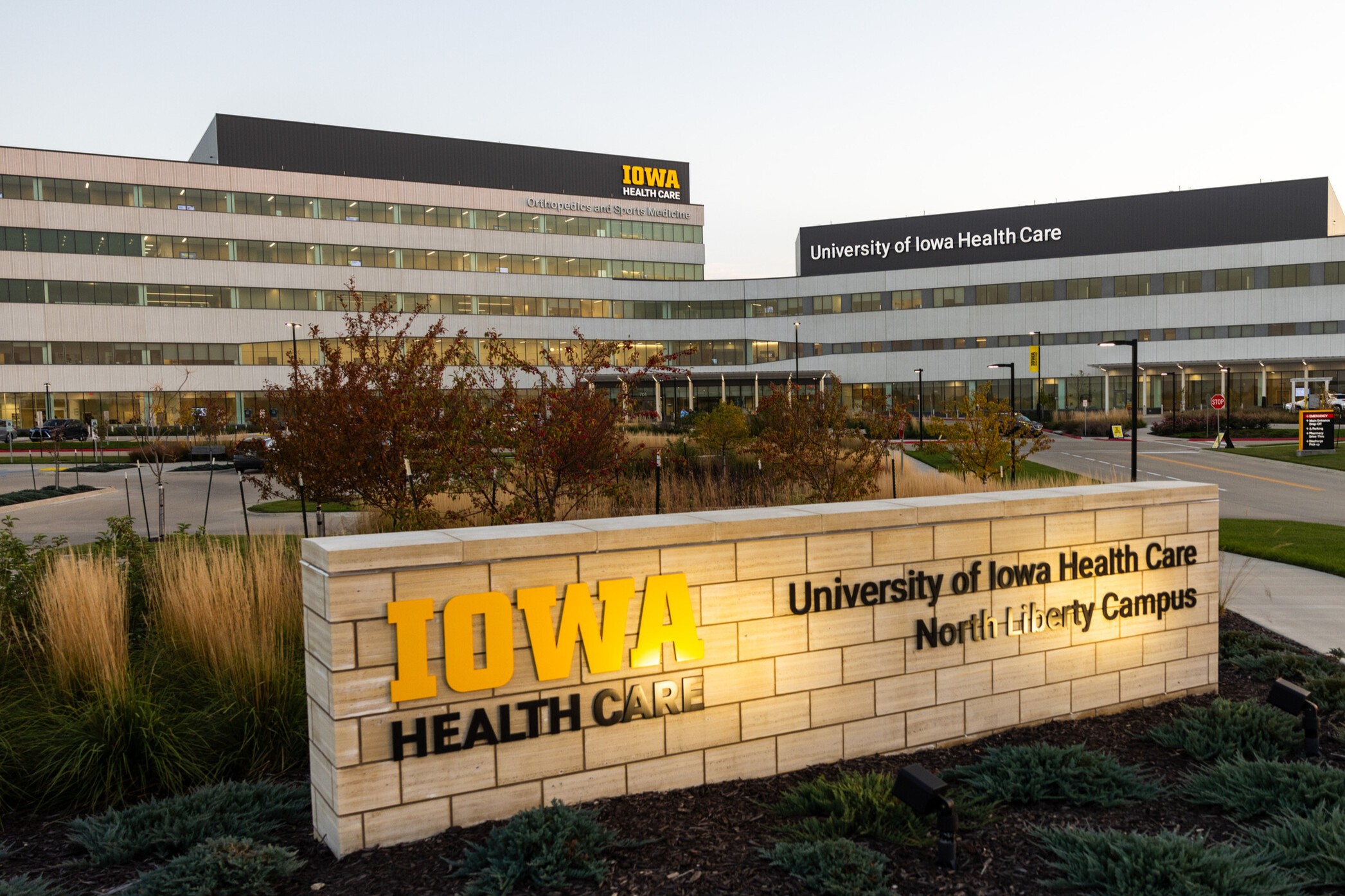 UI Health Care North Liberty campus as evening draws near. Soft lighting and the sign out front is lit.